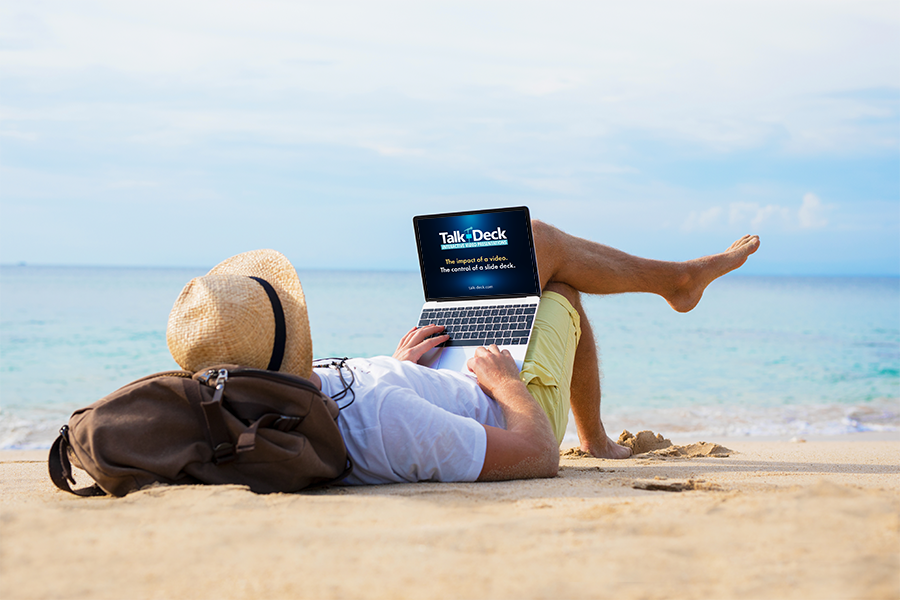 Man reclining on a sunny beach with a laptop, crafting a story in a relaxed, remote setting.